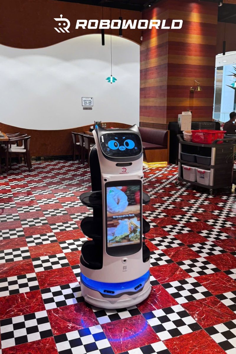 BellaBot Pro mang món trong nhà hàng sàn caro đỏ trắng
