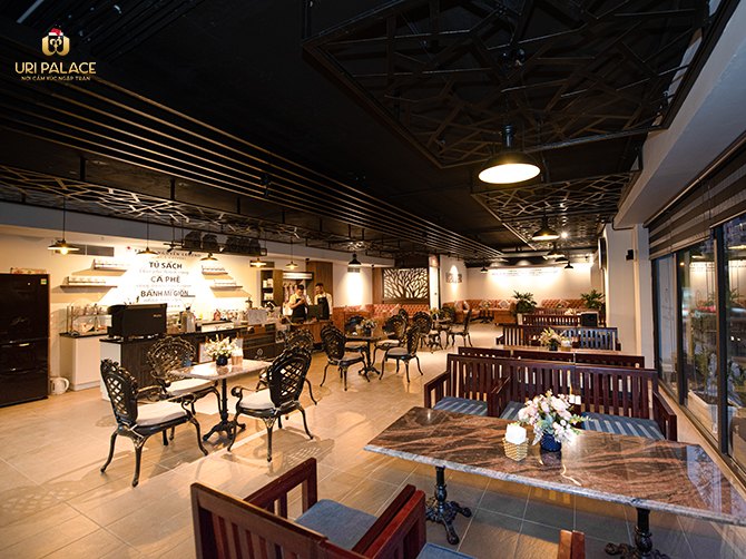 Khu café tầng 1 với bàn ghế sắt, lối đi hẹp